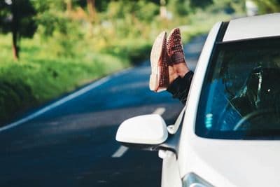 Feet hanging out of a car window