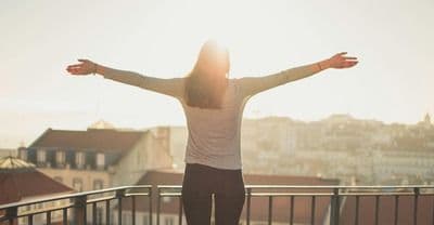 Woman standing in front of the sunrise
