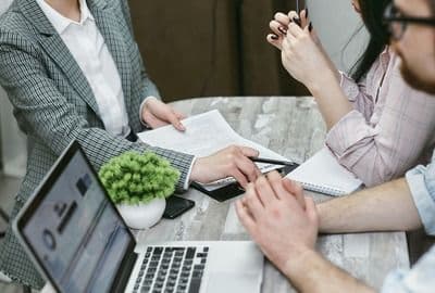 3 people at a table looking over commercial insurance documents