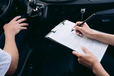 Two people in a car going over the car insurance contract