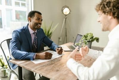 Two men discussing General Liability Insurance at a desk